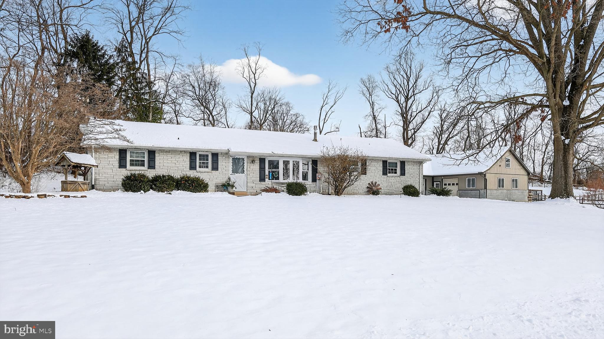 a front view of a house with a yard covered with snow