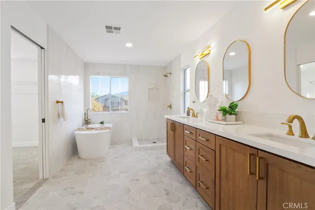 a spacious bathroom with a double vanity sink mirror and bathtub