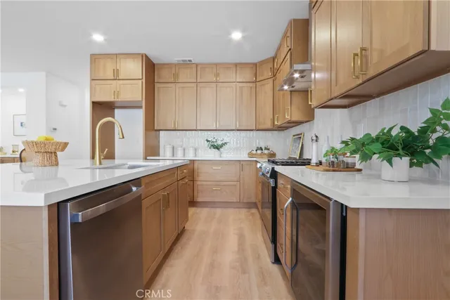 a kitchen with stainless steel appliances granite countertop a sink a stove and a refrigerator