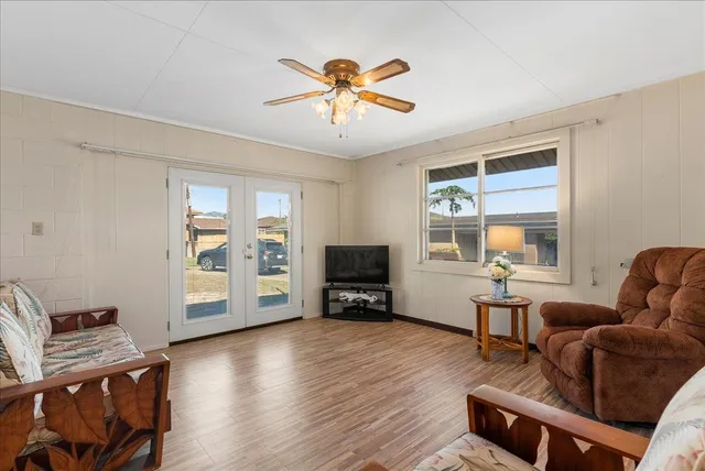 a living room with furniture and a flat screen tv with wooden floor