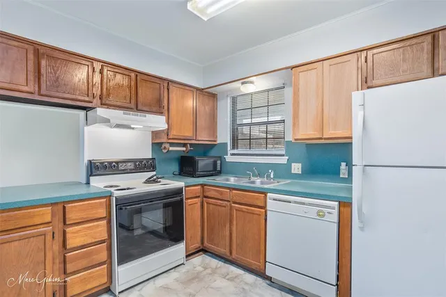 a kitchen with granite countertop cabinets stainless steel appliances a sink and a window