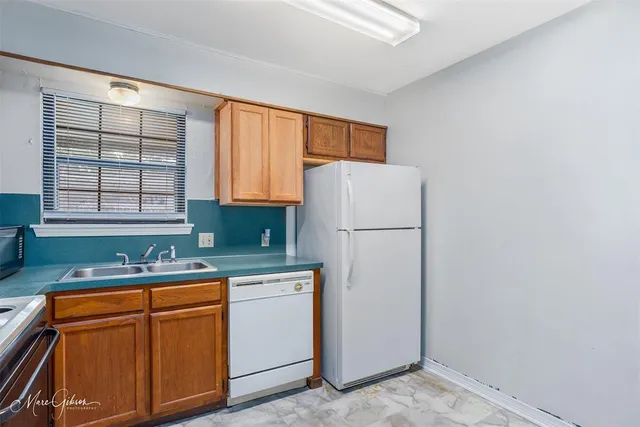 a kitchen with a refrigerator sink stove and cabinets