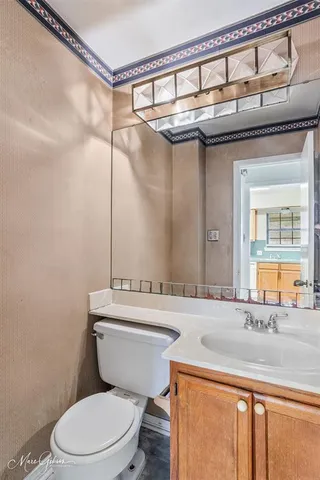 a bathroom with a granite countertop sink a toilet and a mirror