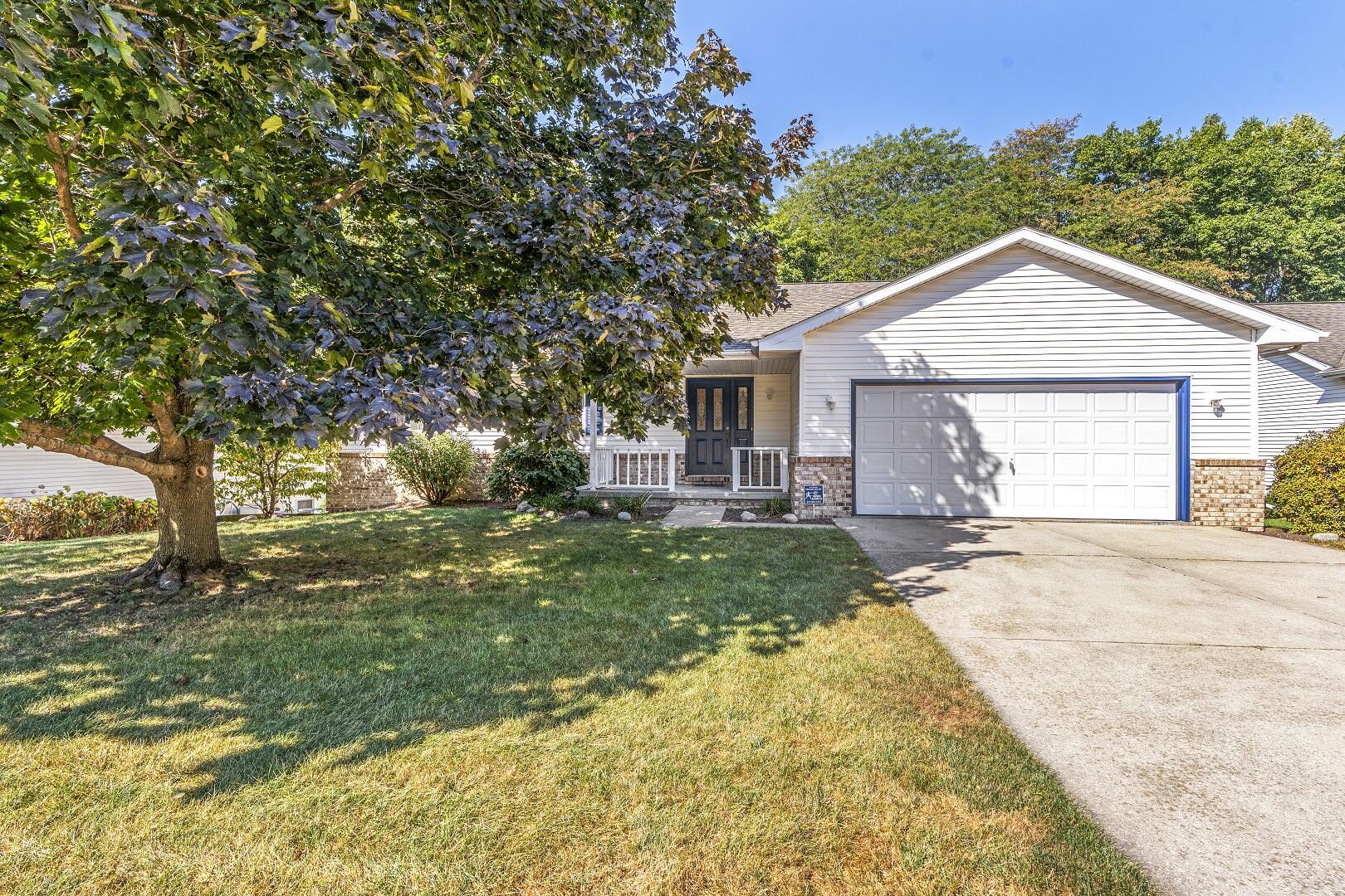 a view of a house with a yard and large tree