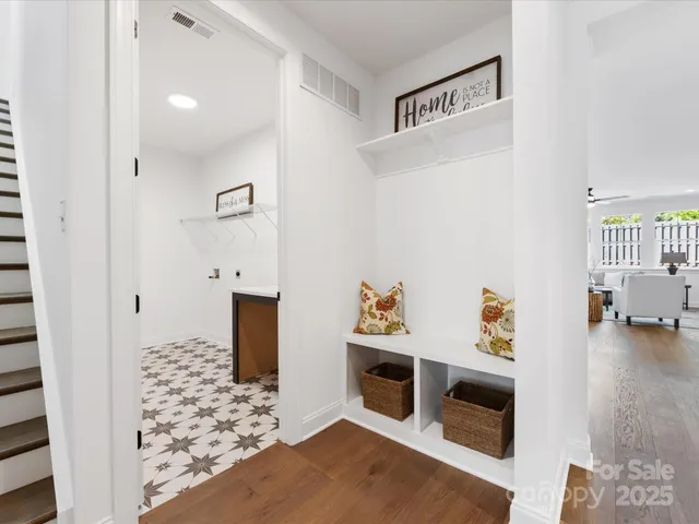 a view of a dining room and livingroom with furniture wooden floor a chandelier