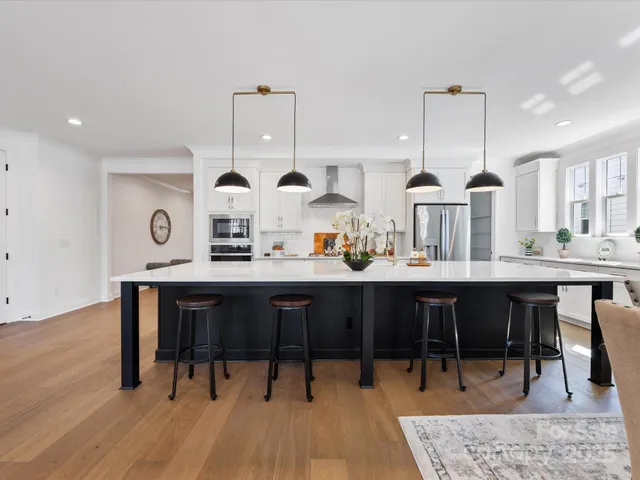 a view of a dining room and livingroom with furniture wooden floor a rug a rug and a chandelier