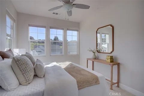 a bedroom with a bed mirror and window
