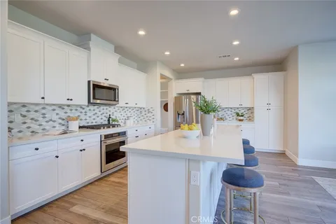 a kitchen with stainless steel appliances granite countertop a sink a stove and a refrigerator