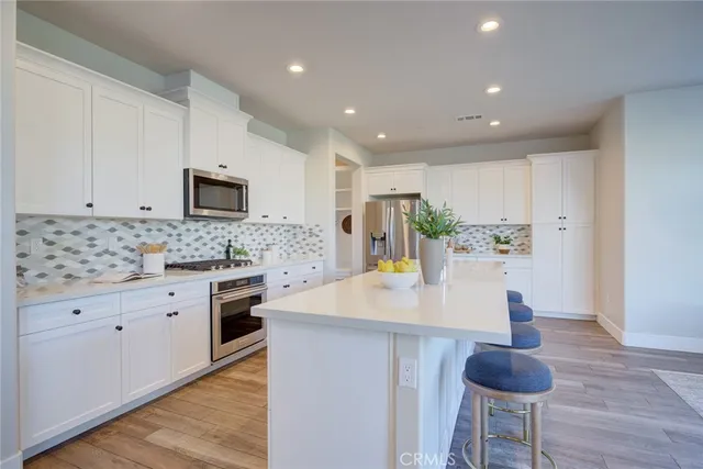 a kitchen with stainless steel appliances granite countertop a sink a stove and a refrigerator
