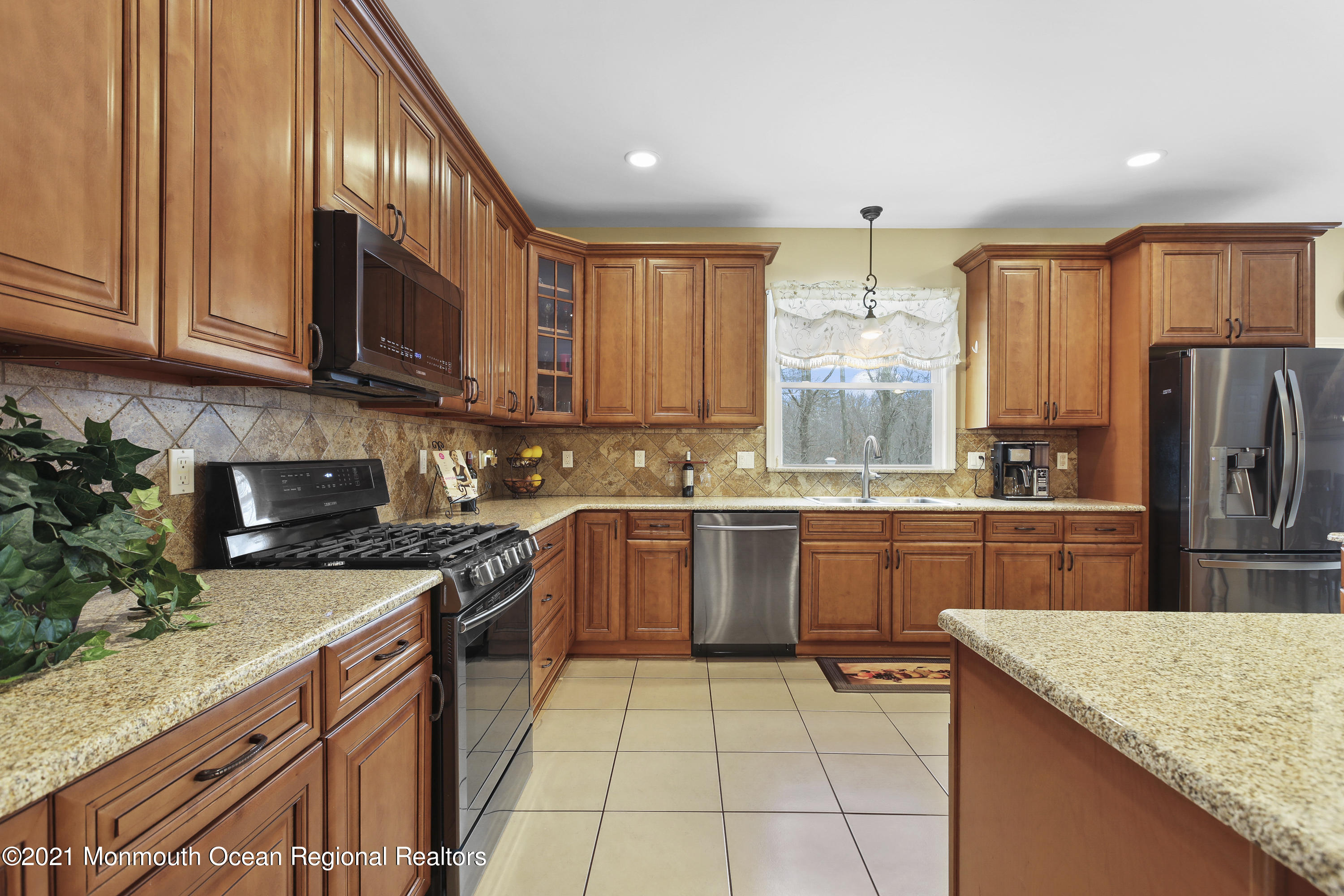 582 Reed Road Jackson, NJ 08527 - Photo 8 of 45 a kitchen with stainless steel appliances granite countertop a stove top oven a sink dishwasher and a refrigerator with wooden cabinets