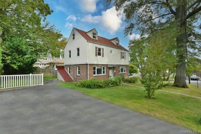 a view of a house with a big yard and large trees