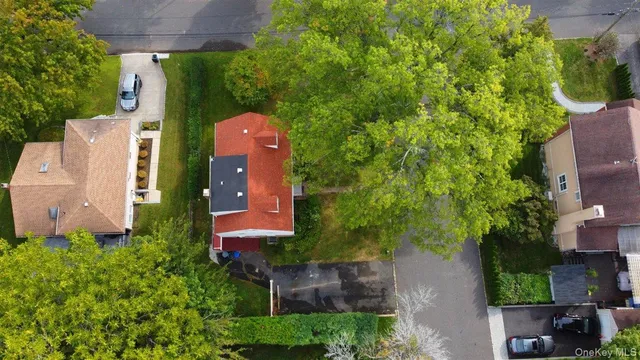 a view of a house with a big yard plants and large trees