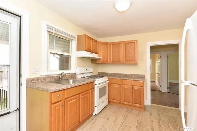 a kitchen with stainless steel appliances granite countertop a sink and cabinets with wooden floor