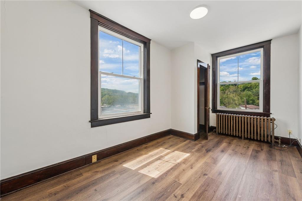206 North Warren Avenue Apollo, PA 15613 - Photo 12 of 23 an empty room with wooden floor and windows