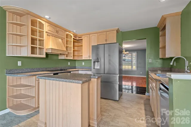 a kitchen with stainless steel appliances granite countertop a refrigerator and a stove