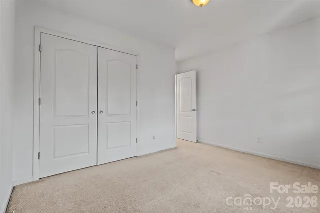 a view of an empty room with yellow carpet