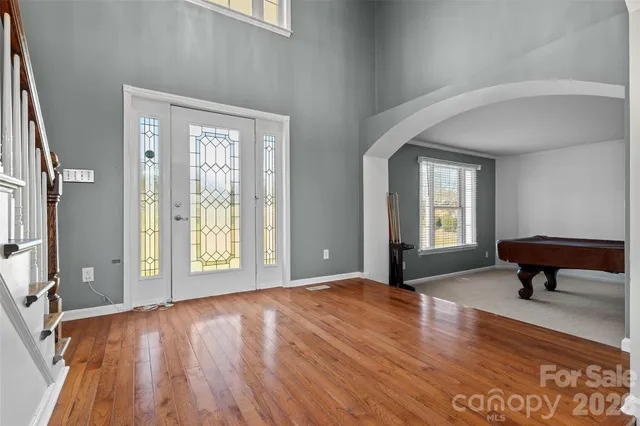 a view of an empty room with glass door and wooden floor