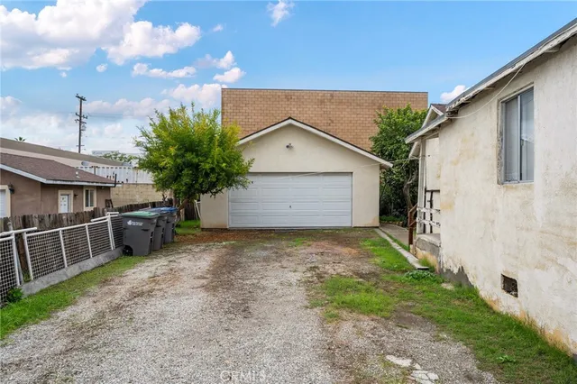 a view of a backyard with plants and a garage
