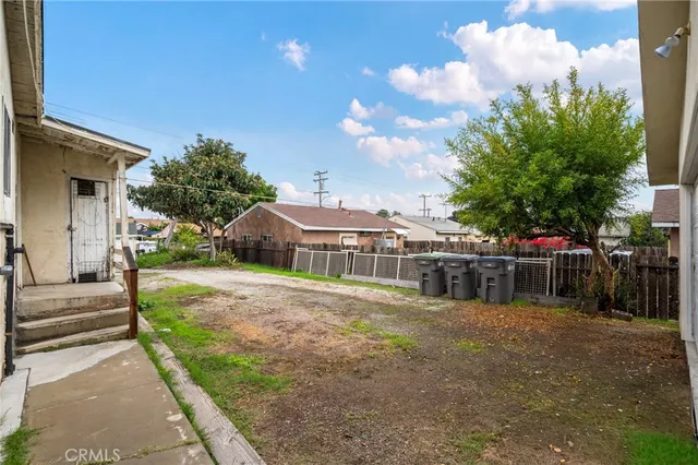 a view of a house with backyard and trees