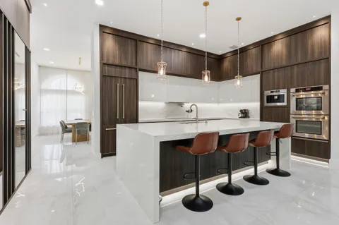 a kitchen with cabinets and chairs