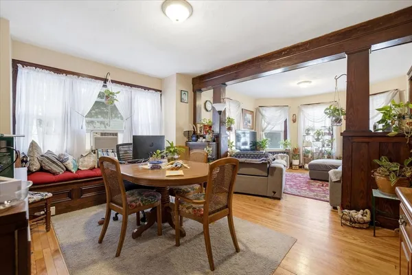 a dining room with furniture window and wooden floor