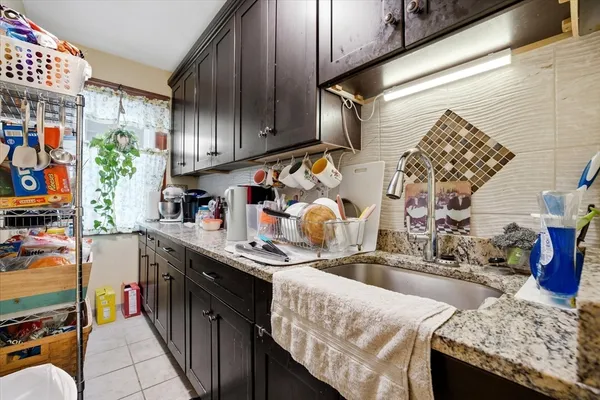 a kitchen with granite countertop lots of clutter and stainless steel appliances