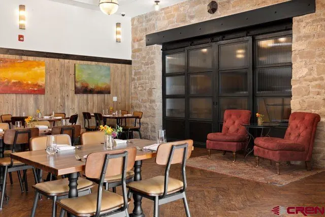 a dining room with furniture and a floor to ceiling window