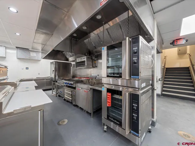 a kitchen with a sink a stove and chairs
