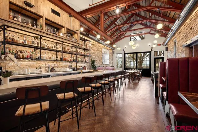 a dining hall with stainless steel appliances granite countertop a dining table and chairs