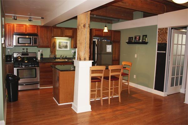 25 Cedar Street, Unit 3 Amesbury, MA 01913 - Photo 3 of 13 a dining room with wooden floor and stainless steel appliances