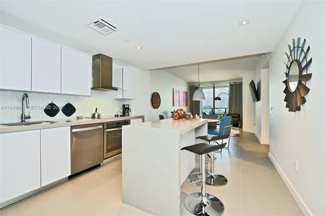 a living room with a couch and a dining table with wooden floor