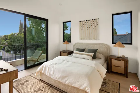 a bedroom with a bed wooden floor and window