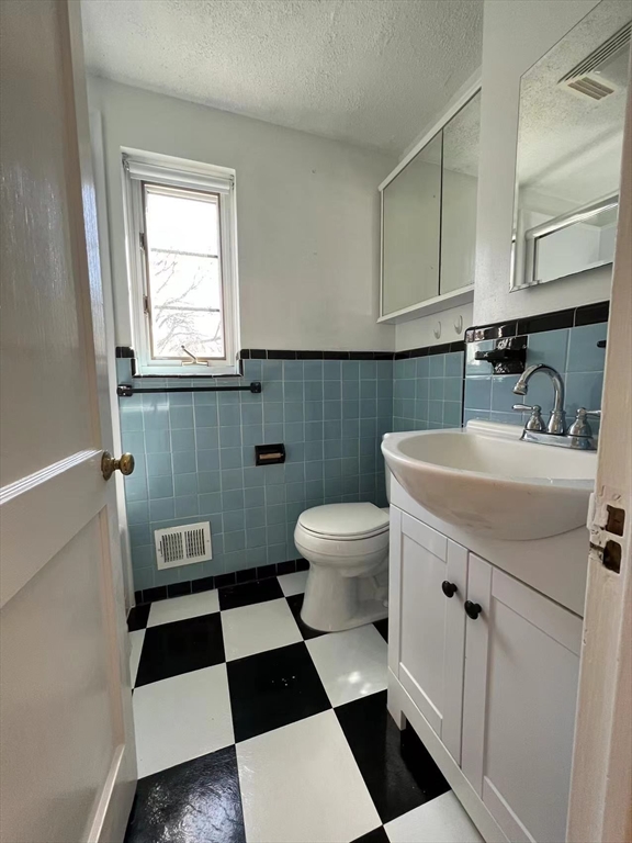 92 Duff Street Watertown, MA 02472 - Photo 6 of 18 a bathroom with a sink a toilet and a mirror