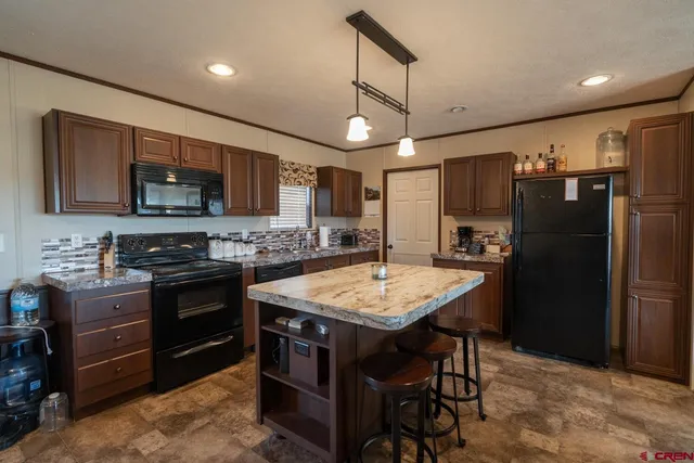a kitchen with stainless steel appliances granite countertop a stove refrigerator sink microwave and cabinets