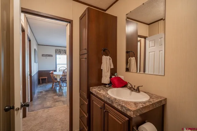 a en suite bathroom with a granite countertop sink and a mirror
