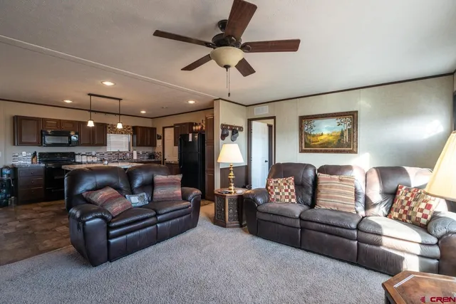 a living room with furniture and a ceiling fan