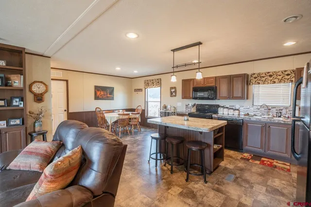 a living room with stainless steel appliances kitchen island granite countertop furniture and a kitchen view