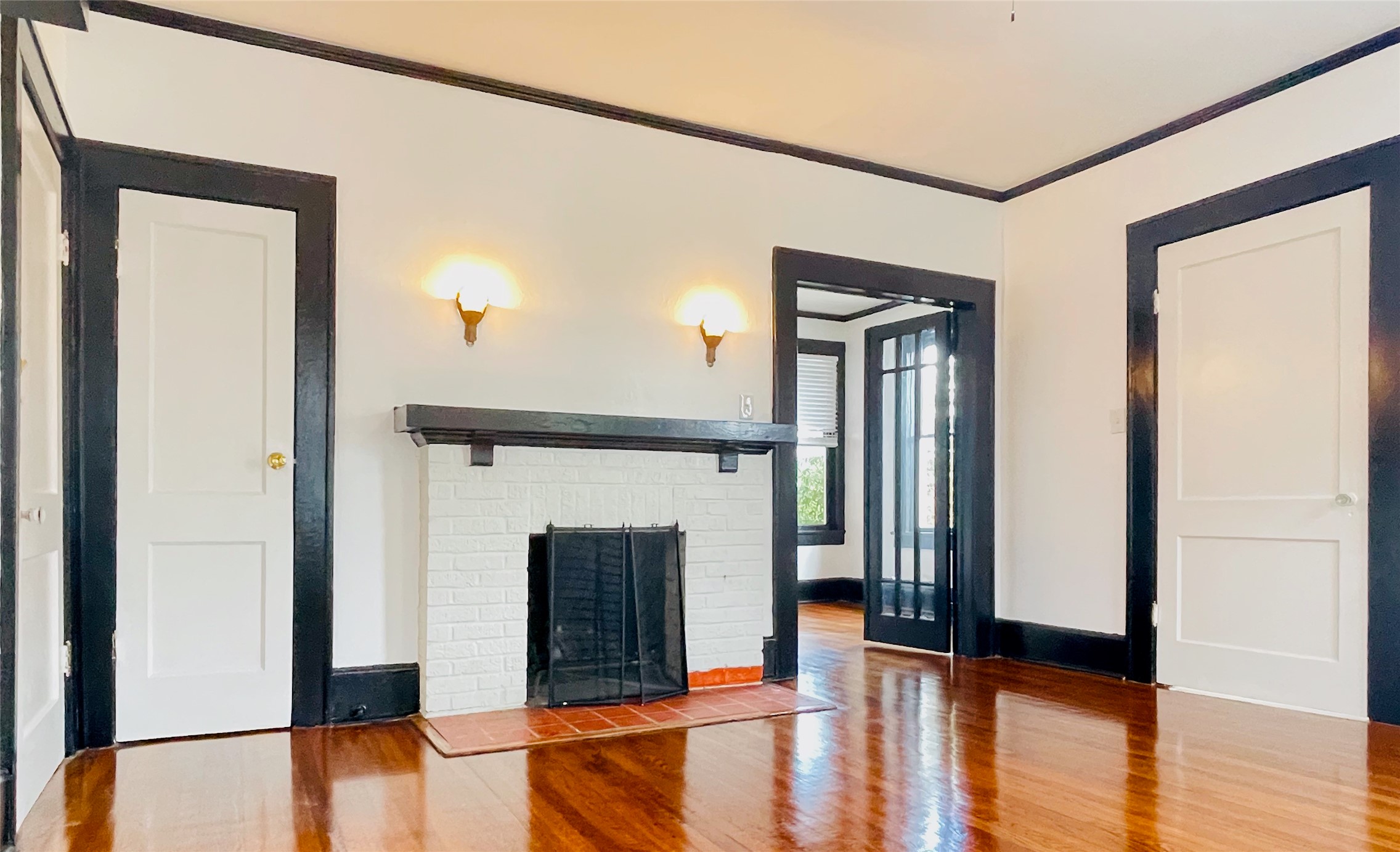 a view of a livingroom with a fireplace wooden floor and a kitchen