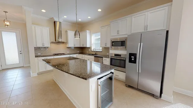 a kitchen with granite countertop a refrigerator a sink a stove a microwave and island
