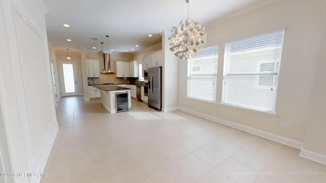 a view of a dining room with furniture a chandelier and window