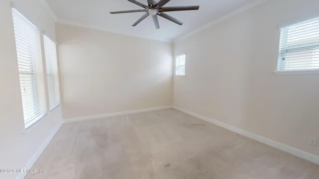 an empty room with windows and fan