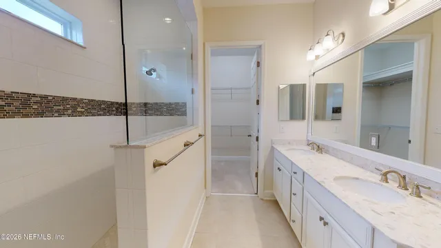 a bathroom with a double vanity sink mirror and shower
