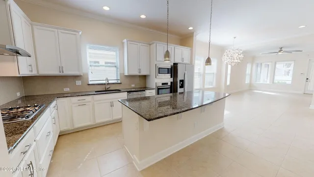 a kitchen with stainless steel appliances granite countertop a sink a stove and a refrigerator