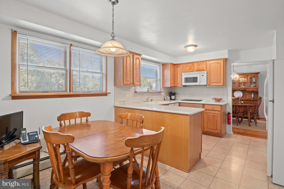 1538 Windmill Road Warminster, PA 18974 - Photo 16 of 32 a kitchen with stainless steel appliances granite countertop a stove a sink a dining table and chairs