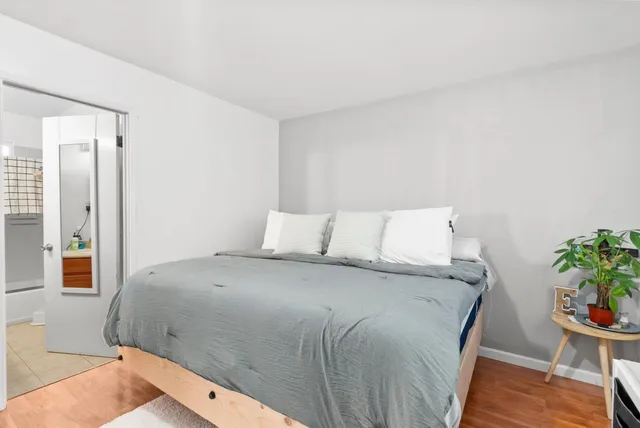 a bedroom with a bed and a potted plant