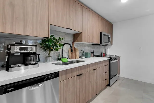a kitchen with stainless steel appliances a sink a stove and cabinets