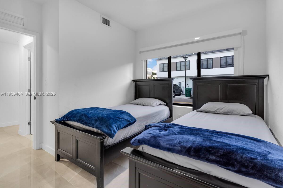 14502 Southwest 260th Street Homestead, FL 33032 - Photo 2 of 8 a bedroom with two beds and dresser