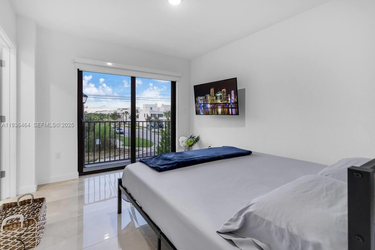 14502 Southwest 260th Street Homestead, FL 33032 - Photo 5 of 8 a bedroom with a bed and a large window