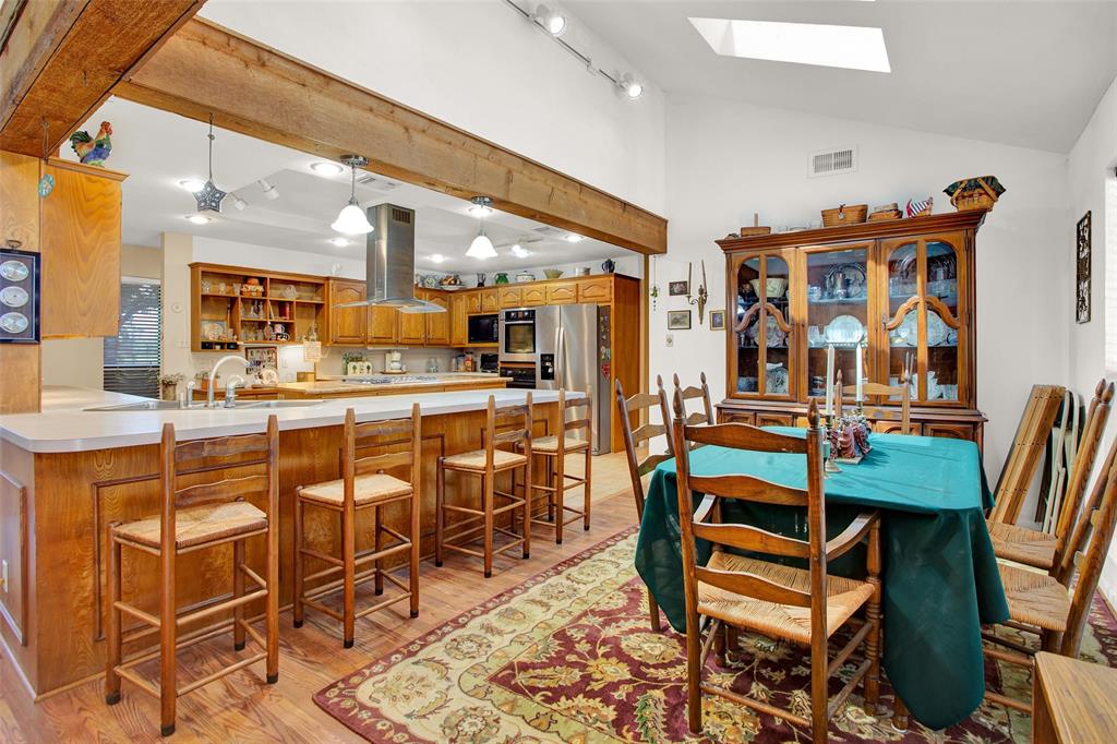 7146 Refuge Road Pottsboro, TX 75076 - Photo 19 of 39 a dining hall with stainless steel appliances a dining table and chairs with wooden floor