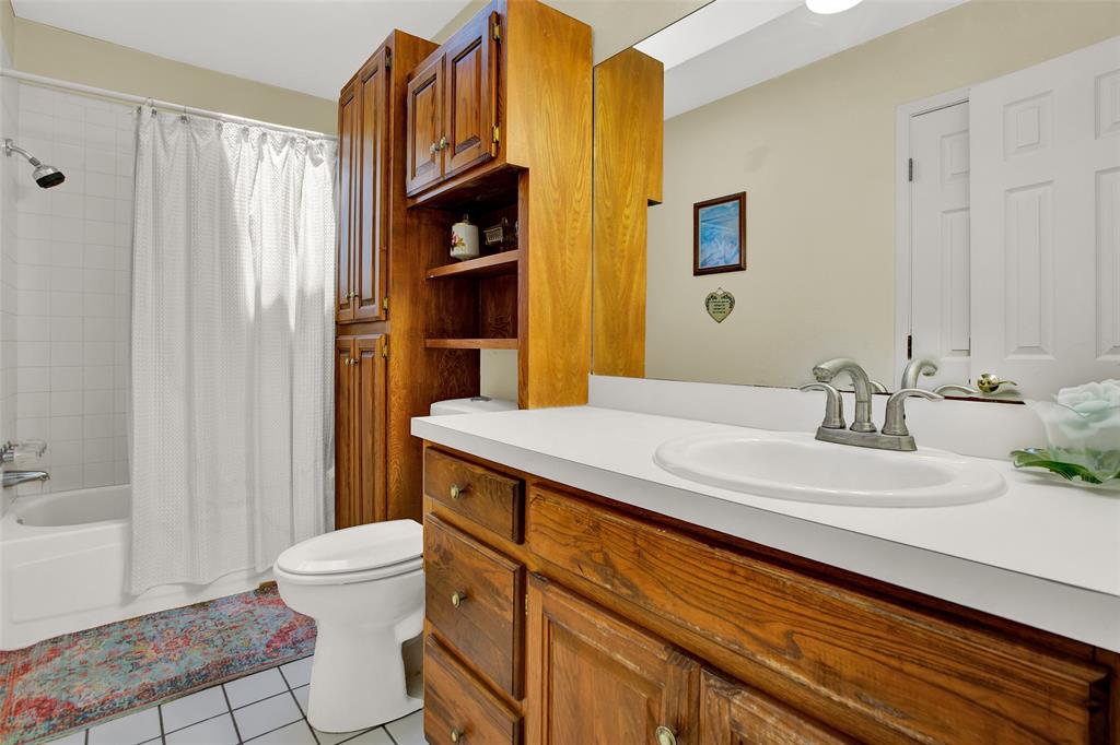 7146 Refuge Road Pottsboro, TX 75076 - Photo 25 of 39 a bathroom with a sink a toilet and shower curtain